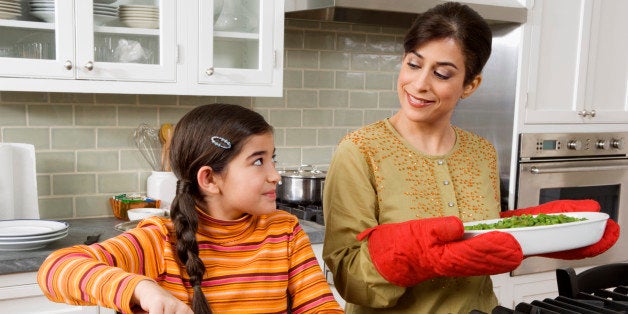 Mother and daughter cooking Thanksgiving meal in kitchen