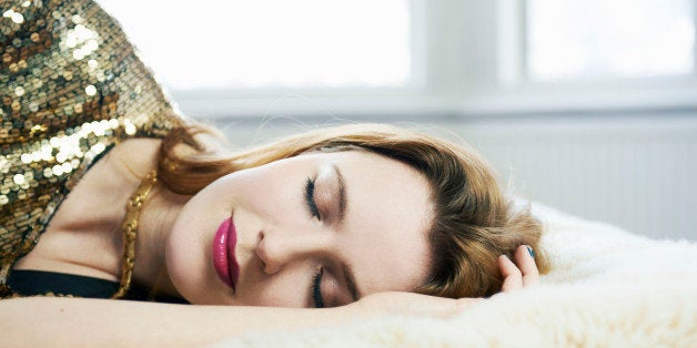 woman dressed up asleep on bed