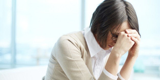 Portrait of tired woman touching her head