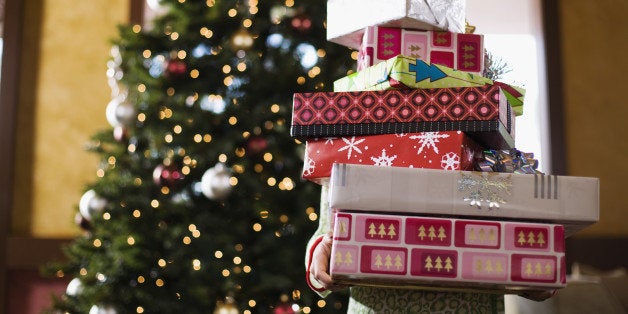 Child holding stack of Christmas gifts