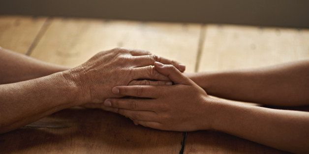 A cropped shot of a woman holding a loved one's hand in support