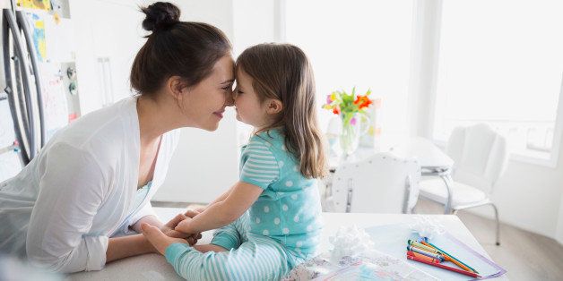 Affectionate mother and daughter rubbing noses in pajamas