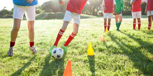 Girls soccer team (aged 12-13) training with their coach