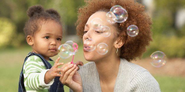 African mother and toddler blowing bubbles