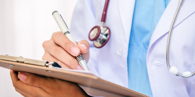 front view of doctor writing information on her folder with a pen