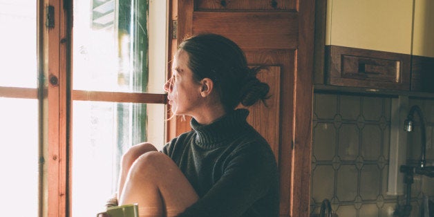 Girl sitting in the kitchen with a coffee mug