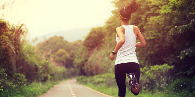 young fitness woman runner running at forest trail