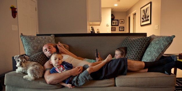 Caucasian father and children relaxing on sofa