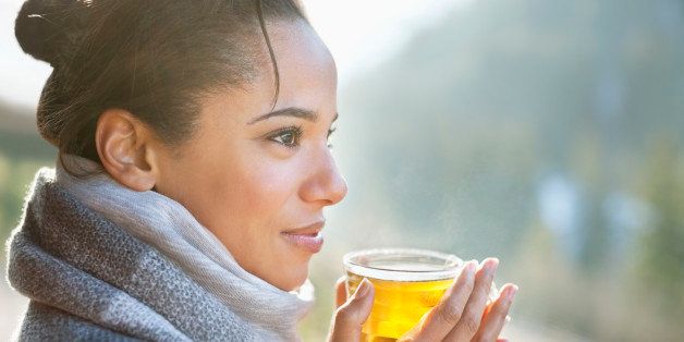 Close up of smiling woman drinking tea outdoors