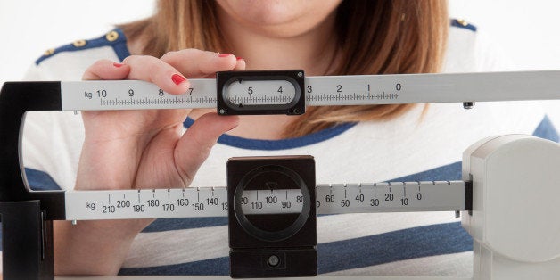 Close-up view of a woman adjusting a medical weight scale
