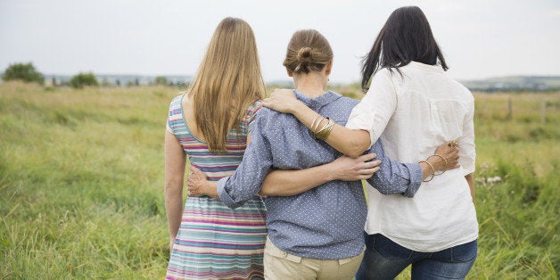 Rear view of female family members walking through field