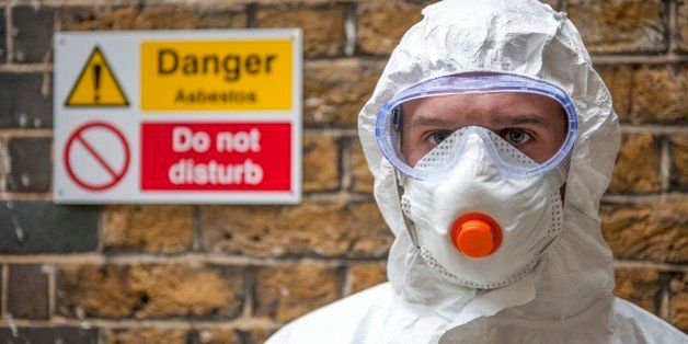 Asbestos protection. Worker wearing protective clothing, a face mask and safety goggles.