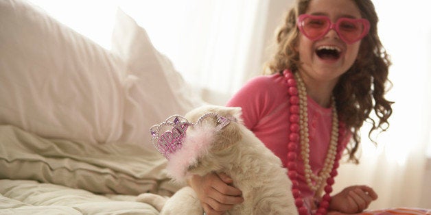 Young girl (8-10) with dog on bed, smiling