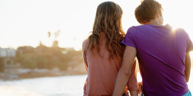 South Africa, Cape Town, Rear view of young couple sitting at beach