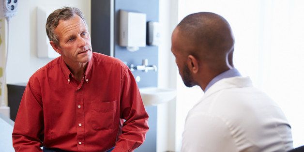 Male Patient And Doctor Have Consultation In Hospital Room