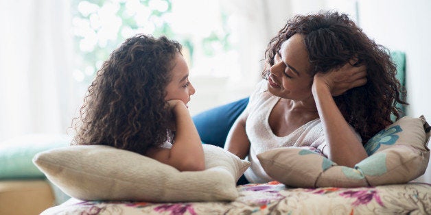 USA, New Jersey, Jersey City, Mother with daughter (8-9) talking on bed