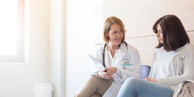 Doctor and patient reviewing medical record in clinic lobby