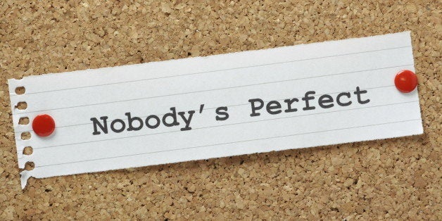 The phrase Nobody's Perfect typed on a piece of lined paper pinned to a cork notice board