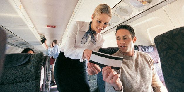 Male Passenger Showing His Ticket to an Air Stewardess on an Aeroplane
