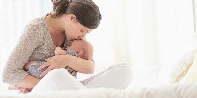 USA, New Jersey, Jersey City, Mother kissing baby boy (2-5 months ) in bed
