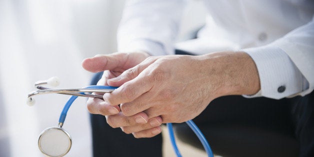 Mixed race doctor's hands holding stethoscope