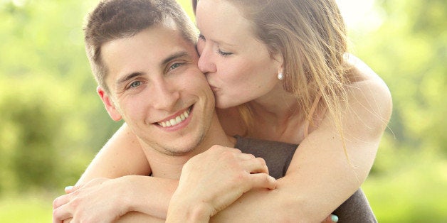 Handsome man with beautiful woman kissing him.