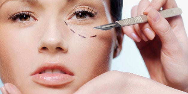 Hands holding a scalpel and a woman's face with a dotted line under her eye