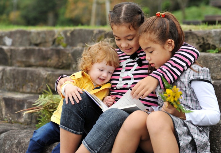 three kids reading a book