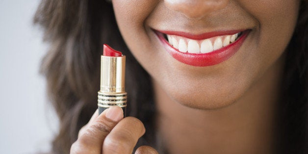 Black woman holding lipstick