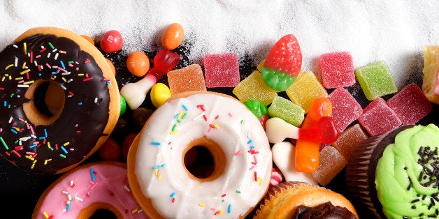 mix of sweet cakes, donuts and candy with sugar spread and written text in unhealthy nutrition, chocolate abuse and addiction concept, body and dental care