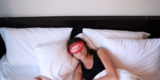 Young beautiful woman sleeping in bed with eye mask