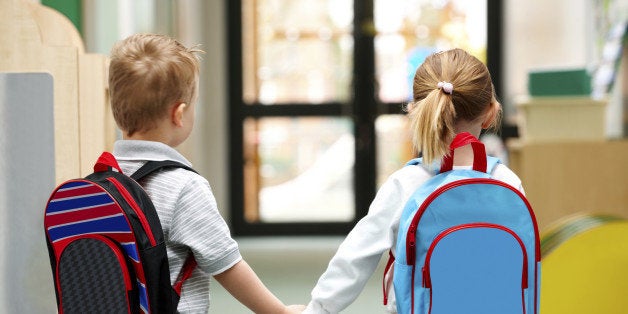 Two cute little children walking to school - Rear view