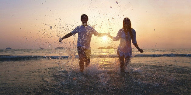 happy couple enjoy sunset on the beach