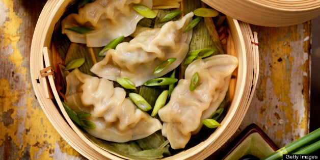 Steamed Dumplings in a bamboo steamer with bamboo leaves, fresh green onions, soya sauce and rice -Photographed on Hasselblad H1-22mb Camera