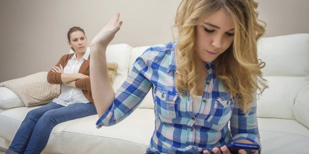 Teenage daughter looking messages in a smartphone and ignoring her furious mother. Bad family communication concept by new technologies