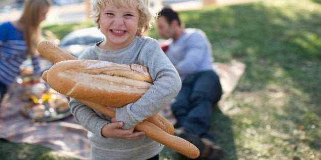 Boy holding loaves of bread outdoors