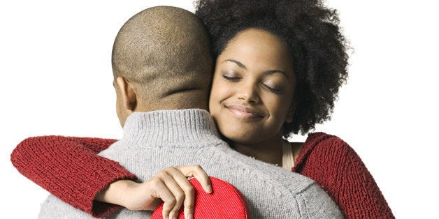 portrait of a young adult couple as the girl hugs her boyfriend after getting a valentines gift