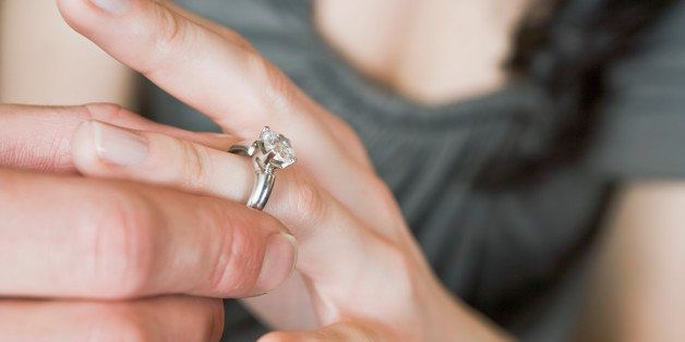 close-up of man putting finger on ring of woman