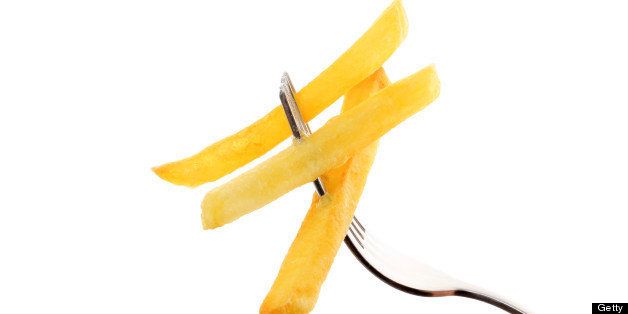 French fries on a fork isolated on white