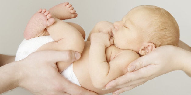 baby newborn sleeping on parents hands, kid and family concept.