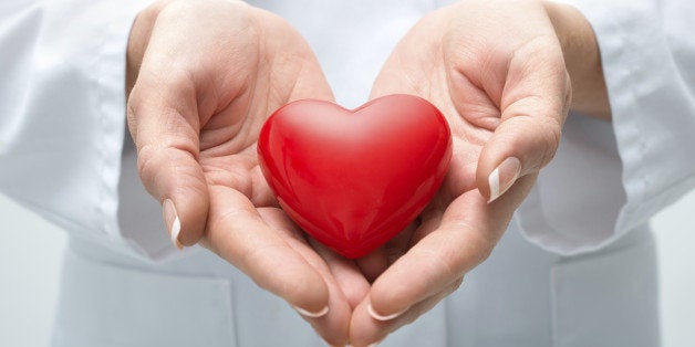 Female doctor with the stethoscope holding heart