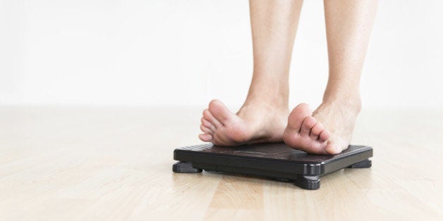 Woman's feet on a scale. Metaphor for diet and healthy living. Close-up with Shallow DOF.