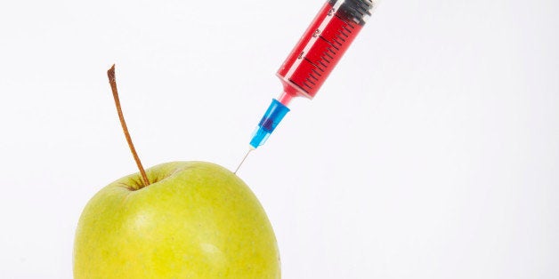 Granny smith apple being injected over white background