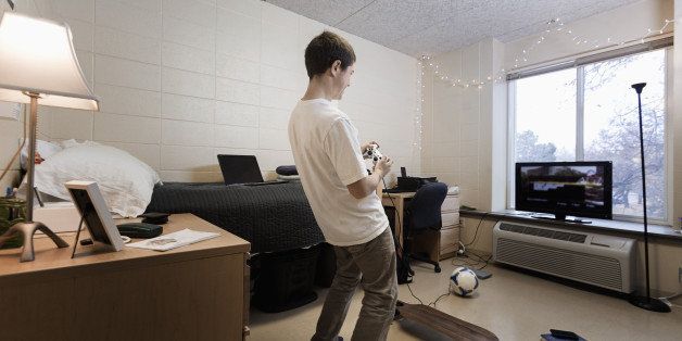 Caucasian student playing video games in dorm room