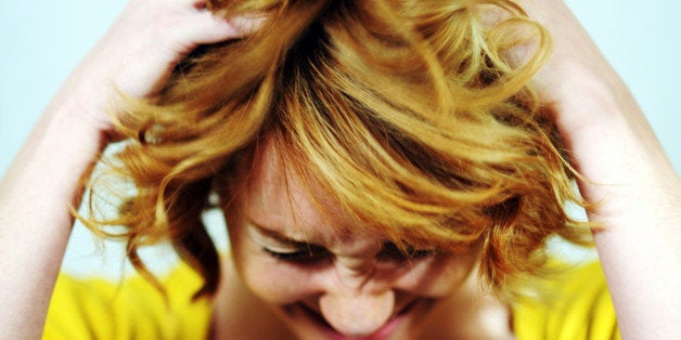 Portrait of a young woman running her hands through her hair.