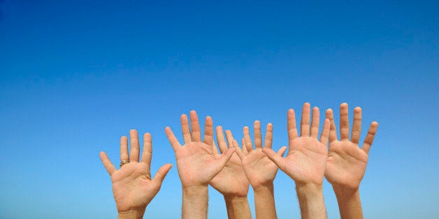 People's hands in air, palms outstretched,