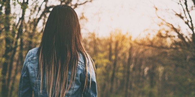 Brunette young woman walking the forest road