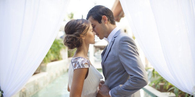 Bride and groom kissing at wedding alter