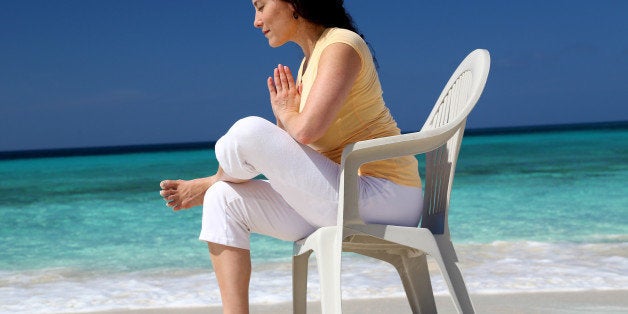 Woman practicing a gentle form of Yoga at waters edge.