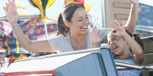 Hispanic mother and daughter riding roller coaster